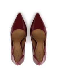 Red patent leather pumps with a pointed toe, a scalloped cutout design, and a smooth texture, featuring a tan interior and logo.