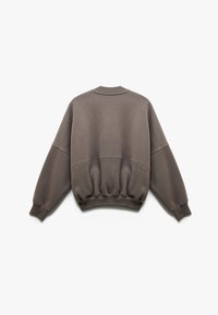 Brun sweatshirt med rund hals, sænkede skuldre og elastisk talje. Lavet af blødt stof med en glat tekstur og ensfarvet.