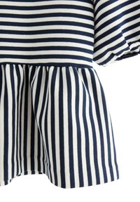 Marineblåt og hvidt stribet stof med vandrette striber øverst og lodrette striber på den rynkede nederdel.