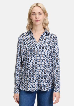 Camicia a maniche lunghe con bottoni in tessuto setoso, caratterizzata da un motivo geometrico nei toni del blu, bianco e beige. Collo classico e maniche con polsini.