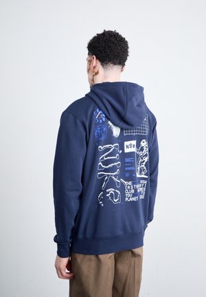 Dunkelblauer Hoodie mit weißen Grafiken und Text auf der Rückseite, einschließlich abstrakter Formen und einer Figur im Raumanzug. Material aus Baumwollmischung.