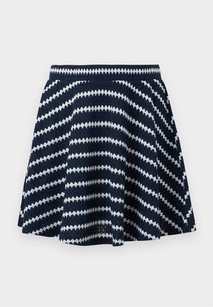 Πλεκτή φούστα σε ναυτικό μπλε με λευκές διαγώνιες ζιγκ-ζαγκ ρίγες και ελαστική μέση, με φουσκωτή σιλουέτα.