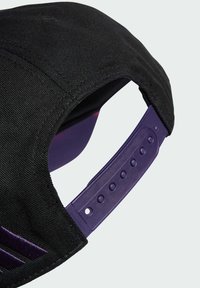 Gorro negro con un tejido texturizado y un cierre de snapback púrpura. Presenta detalles bordados en púrpura oscuro en la parte delantera.