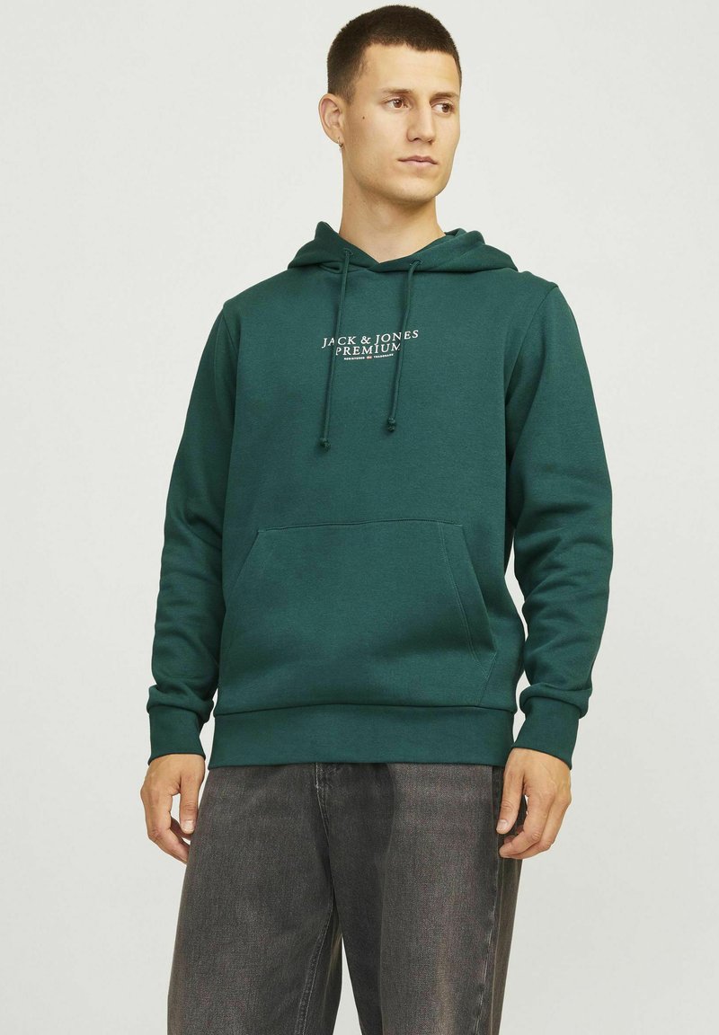 Dunkelgrüner Hoodie aus weichem Stoff, mit einer Fronttasche, verstellbarem Kordelzug in der Kapuze und weißem Logo-Text auf der Brust.