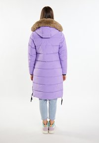 Pardosel cuînă cu guler din blană sintetică, având un design lung, textură matlasată și detalii cu șnururi la tiv.