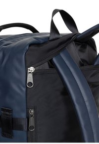 Sac à dos noir et marine avec extérieur texturé, double compartiments zippés et poignées en tissu robustes.