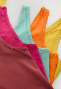 Stack of sleeveless tops in brown, pink, light blue, orange, and yellow, arranged overlapping on a white surface.