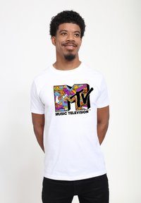 White cotton t-shirt featuring a colorful MTV logo with intricate patterns. The logo includes stylized graphics and bold black text.