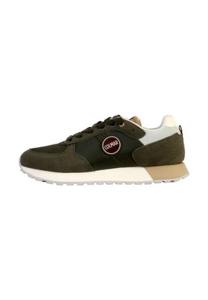 Donkergroene suède sneaker met witte en tan accenten. Kenmerkt zich door een ronde logo aan de zijkant, vetersluiting aan de voorkant en een gestructureerde rubberen zool.