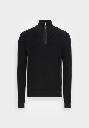 Pull noir en maille avec manches longues, texture côtelée et col demi-zip argenté sur un fond clair uni.