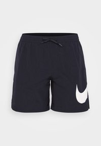 Pantaloni da nuoto blu navy realizzati in tessuto leggero, con vita elastica e cordino, e un grande logo bianco della Nike sul lato sinistro.