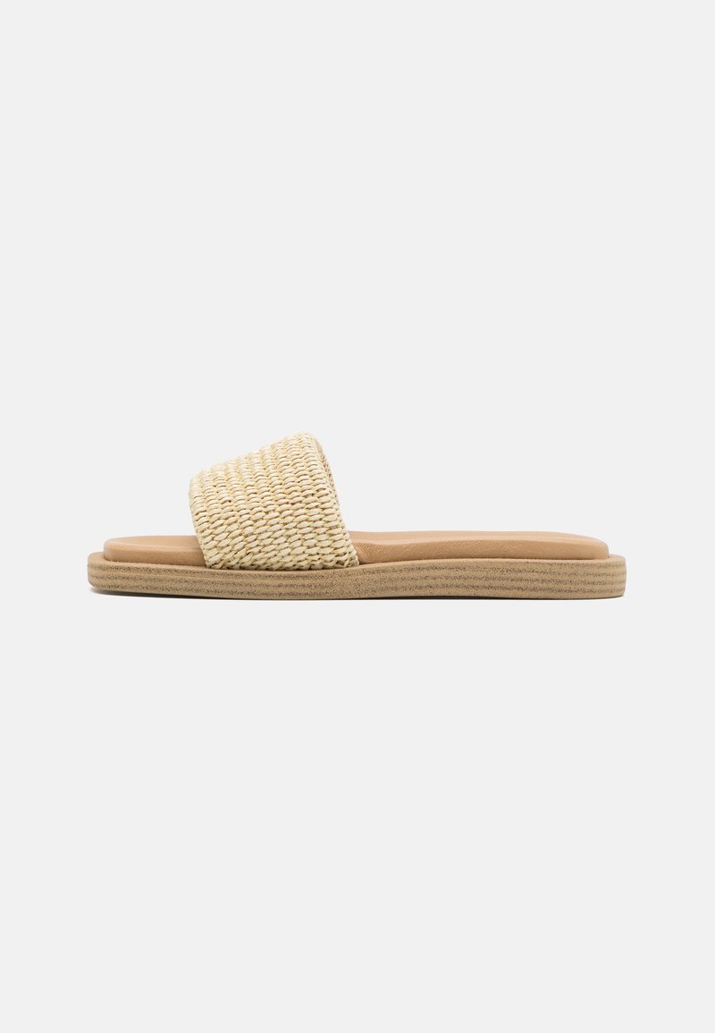 Sandale mule en paille tissée beige avec une semelle intérieure lisse couleur noisette et une semelle extérieure texturée et profilée basse, dotée d'une large bride plate.