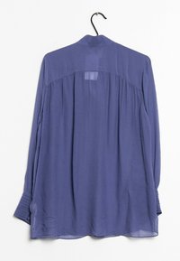 Lilla langærmet bluse lavet af letvægtsstof, med en subtil tekstur, delt ryg og knappede manchetter.