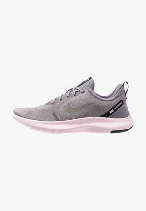 Vue latérale d'une chaussure de running Nike grise avec une semelle rose clair, un laçage à l'avant et un onglet noir au talon.
