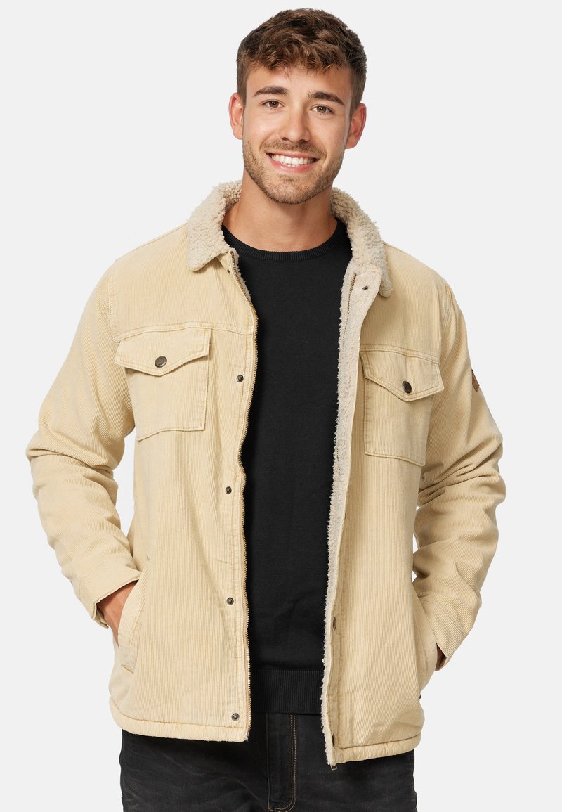 Boucle jas in beige met een gestructureerde, fluffy kraag. Beschikt over borstzakken en zijzakken, knoopsluiting en geribbelde manchetten.