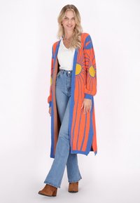 Cardigan lungo in un vibrante arancione e blu, con motivi di sole gialli. Tessuto a maglia comoda, design aperto e polsini a costine.