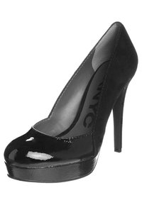 Chaussure à talon haut noire, présentant un bout en cuir verni et un corps en daim. Bout arrondi avec une plateforme, talon aiguille élancé et doublure intérieure lisse.