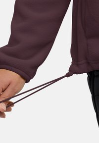 Bordeaux fleecejack met een manchette met een verstelbare elastische trekker en trekkoord, die een zachte textuur en praktisch ontwerp benadrukt.