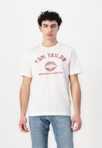 Hvit bomull T-skjorte med korte ermer, med rød tekst "TOM TAILOR" og dekorative grafiske elementer. Jevn tekstur, klassisk passform.