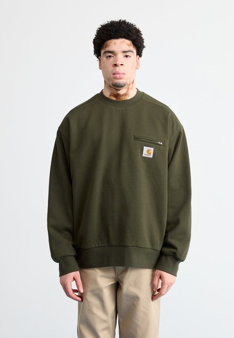 Sudadera verde oliva de tejido suave, con escote redondo, puños acanalados y un pequeño bolsillo con logotipo en el pecho.