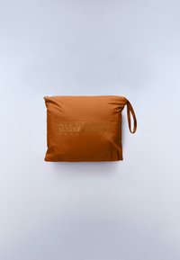 Τετράγωνο πορτοκαλί μαξιλάρι από απαλό ύφασμα με λεία υφή. Διαθέτει λουρί στο πλάι και ανάγλυφο λογότυπο σε πιο ανοιχτή απόχρωση.