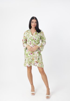 Robe portefeuille à fleurs en vert, avec des motifs roses et violets, manches longues, ourlet à volants et taille cintrée, confectionnée en tissu lisse.