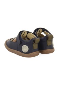 Sandales bleu marine avec design découpé, semelles en caoutchouc tan et accents vert olive. Comprend des sangles ajustables et un détail de logo rond.