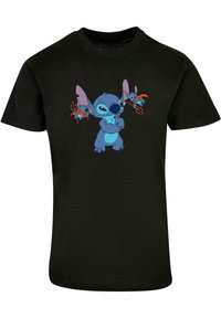 Camiseta de algodón negra con un personaje de dibujos animados azul y orejas grandes, sosteniendo tridentes, en la parte frontal. Diseño gráfico centrado y colorido.
