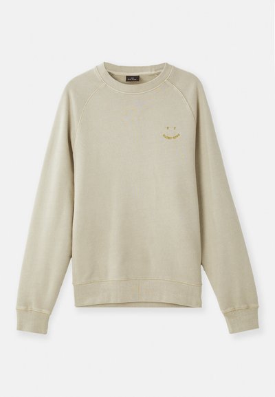 Moleton bege com punhos e bainha canelados, apresentando mangas raglan e um pequeno logótipo de rosto sorridente amarelo no peito. Textura suave.