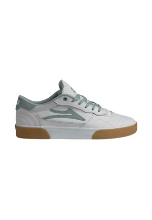 Weißer Sneaker mit niedrigem Schaft, hellgrünen Akzenten, Schnürsenkeln und Gummisohle, von der Außenseite vor weißem Hintergrund gezeigt.