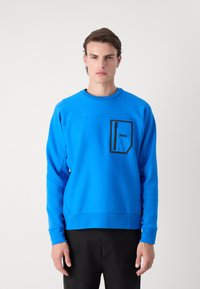 Felpa blu con collo tondo, tasca nera con zip e dettaglio del logo. Tessuto liscio; maniche e orlo attillati; design minimalista.