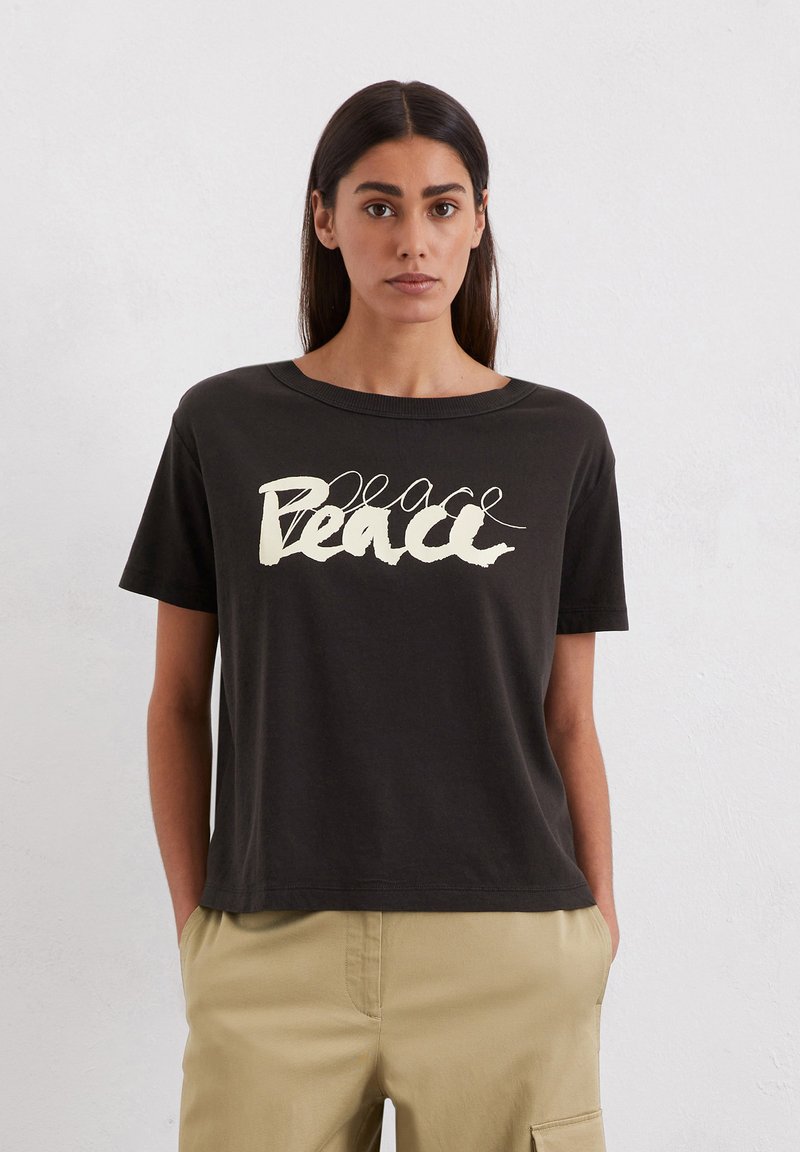 Schwarzes Baumwoll-T-Shirt mit lockerer Passform und Rundhalsausschnitt, mit dem Aufdruck "Peace" in cremfärbiger, geschwungener Schrift auf der Vorderseite.