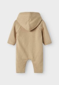 Monosie de punto beige con capucha, mangas largas y puños acanalados. Textura suave y un diseño sencillo sin patrones ni acentos adicionales.