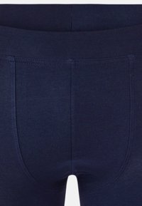 Navy blue leggings valmistettu neuloksesta, jossa on joustava vyötärö ja näkyvät saumat. Ominaisuuksiin kuuluu sileä rakenne ja tiukka design.