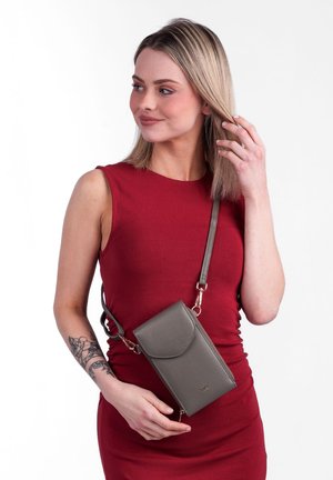 Grau lederne Umhängetasche mit Klappenverschluss und abnehmbarem Tragegurt, vor einem weißen Hintergrund präsentiert.