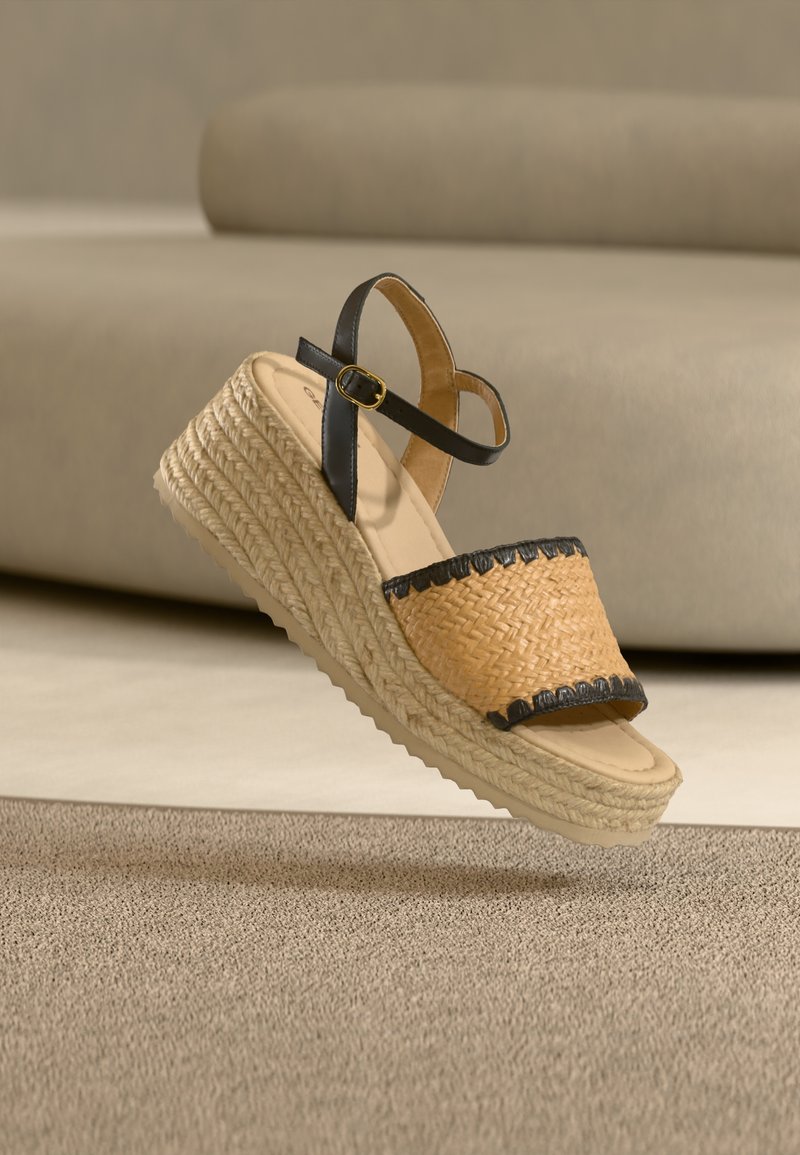 Πλεγμένο σανδάλι πλατφόρμας από άχυρο με μαύρο δερμάτινο λουράκι στον αστράγαλο και διακοσμητικές λεπτομέρειες. Ελαφρύ σχέδιο με υφή σόλας από τζούτ. Παλέτα χρωμάτων: καφέ και μαύρο.