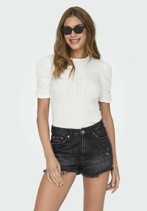 Hvid ribbet strikket kortærmet top med puffærmer, parret med høj talje sorte denim shorts med frynsede kanter og slidte detaljer.