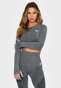 Gray athletic crop top and high-waisted leggings made of textured, stretch fabric. Features a logo accent on the top and leggings.