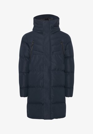 Tumedat sinine puhvjakas kõrge kraega, ees lukk ja kaks lukuga rinnataskut. Omab horisontaalset õmmeldud tekstuuri.