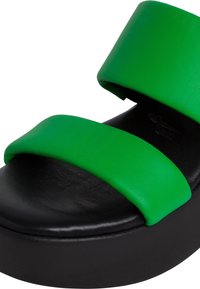 Sandale à plateforme en cuir synthétique vert avec deux larges brides et une semelle noire texturée, présentant un design à bout arrondi.