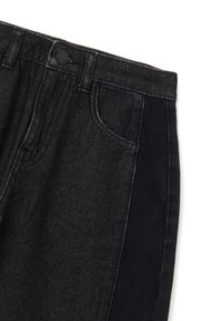 Jeans de denim negro con cierre de botón, bolsillos frontales y un acabado ligeramente desgastado, con una tela texturizada y paneles laterales negros contrastantes.