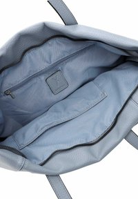 Sac à main bleu clair avec un extérieur en cuir texturé, fermeture éclair et doublure en tissu doux, avec des poches intérieures pour l'organisation.