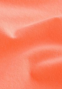 Tela de coral con una textura suave, que muestra un fino patrón de costillas y suaves pliegues. El color es vibrante y uniforme en toda la superficie.