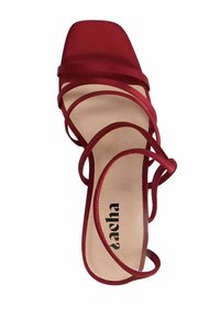 Red strappy high heel sandal with a square toe, designed with smooth straps and a padded insole, featuring a visible brand name on the sole.
