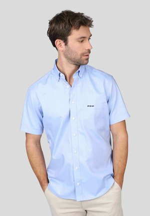 Chemise bleu clair à manches courtes avec des boutons, en coton, dotée d'un col classique et d'un petit logo brodé sur la poche de poitrine.