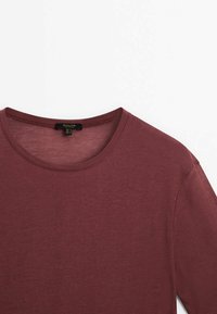 T-shirt bordeaux à manches courtes et col rond en tissu léger, présenté de face sur fond blanc.