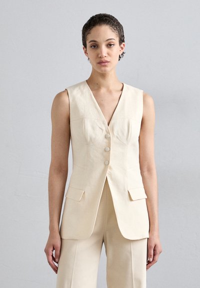 Gilet sans manches beige avec un décolleté en V profond, trois boutons et deux poches avant. Fabriqué à partir d'un tissu léger et texturé. Coupe ajustée.