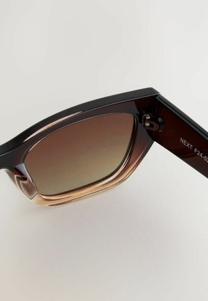 Braune Verlaufssonnenbrille mit rechteckigen Fassungen, ausgestattet mit einer glänzend schwarzen oberen Kante und einem durchsichtigen braunen unteren Bereich.