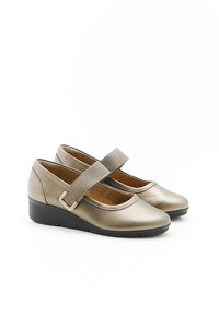 Zapatos con cuña en color dorado metálico, con punta redondeada y una correa elástica con hebilla para un ajuste seguro. Textura suave.