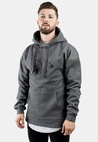 Sudadera gris hecha de una suave mezcla de algodón con bolsillo canguro, capucha ajustable y un diseño gráfico negro en el frente.
